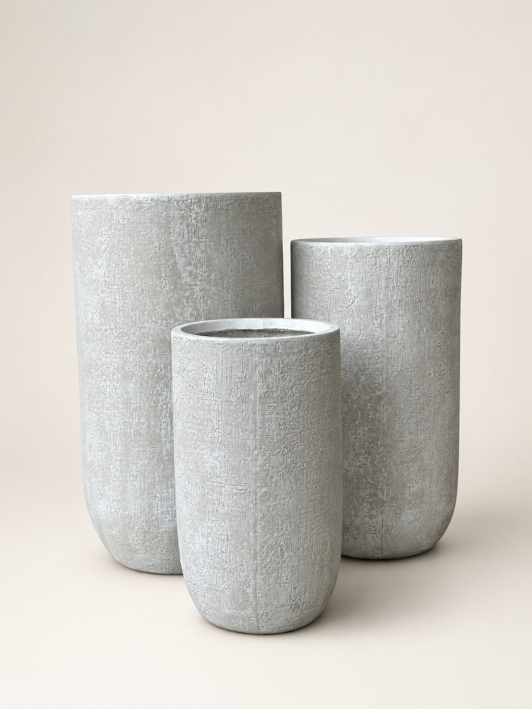 Textured cylindrical planter set, three light gray planters