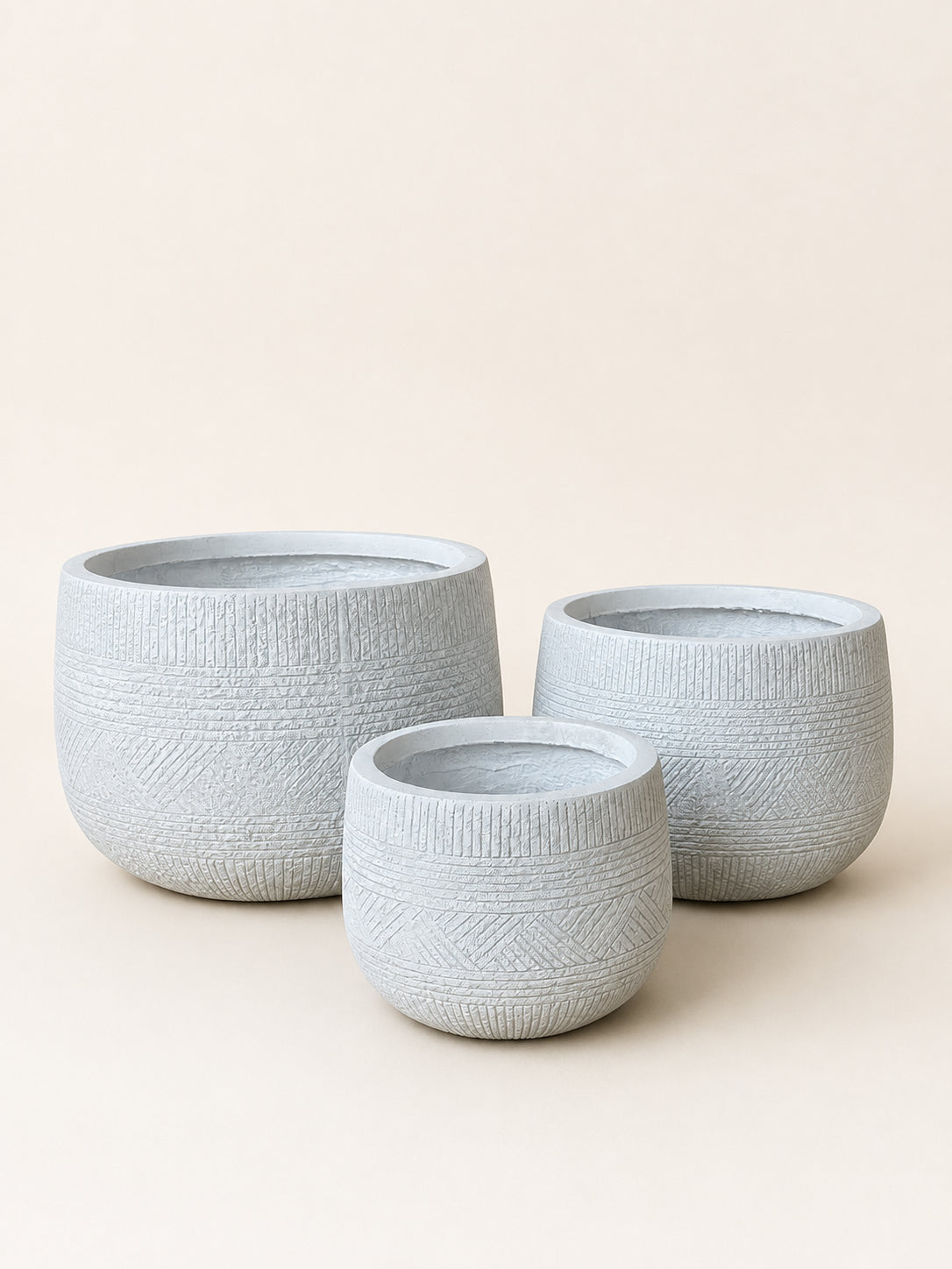 Set of textured white fiber plant pots, three round cylinders in varying sizes
