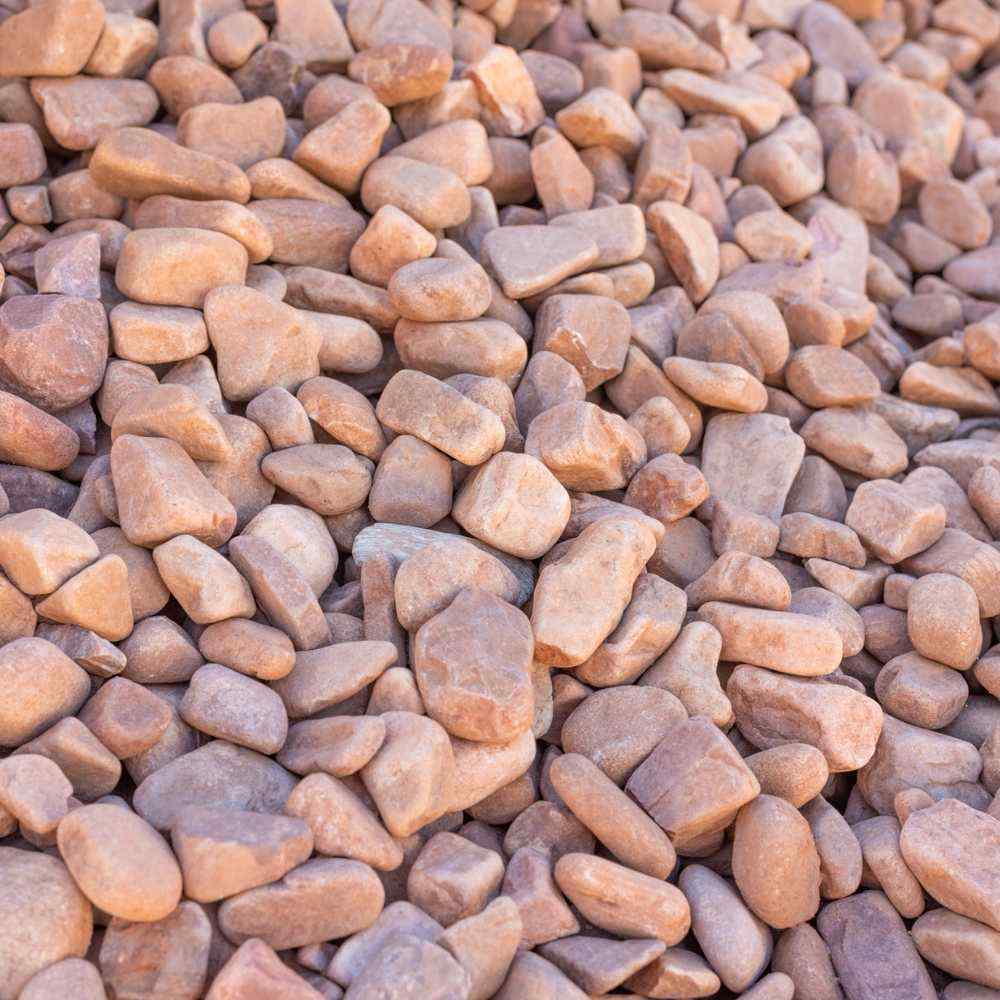 Mixed river pebbles in tan, orange, and gray, smooth rounded stones