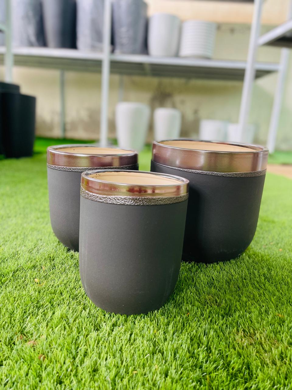 Set of dark ceramic planters with gold rim lines, three cylindrical pots