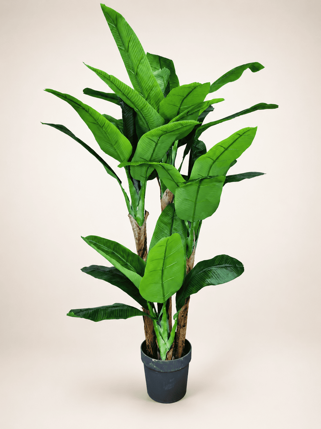 Artificial banana plant with lifelike green leaves in a dark plastic pot