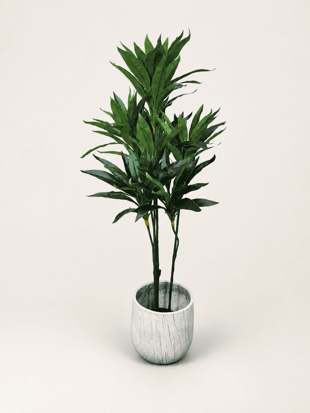 Artificial dracaena reflexa tree with green spiky leaves in light gray round pot