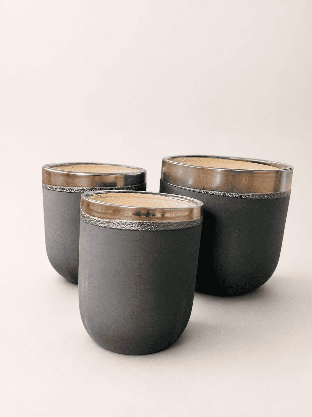Matte black ceramic plant pot trio with thin gold line rim and speckled interior