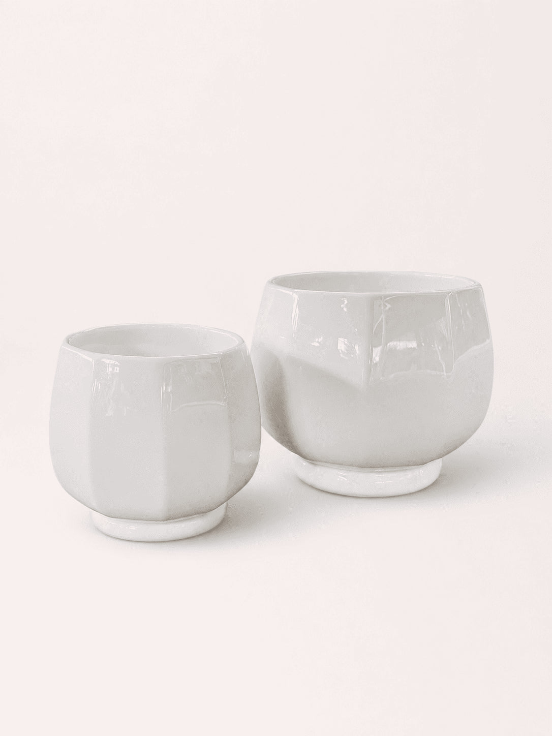 White ceramic low round planter pots, short wide cups with smooth glossy finish.