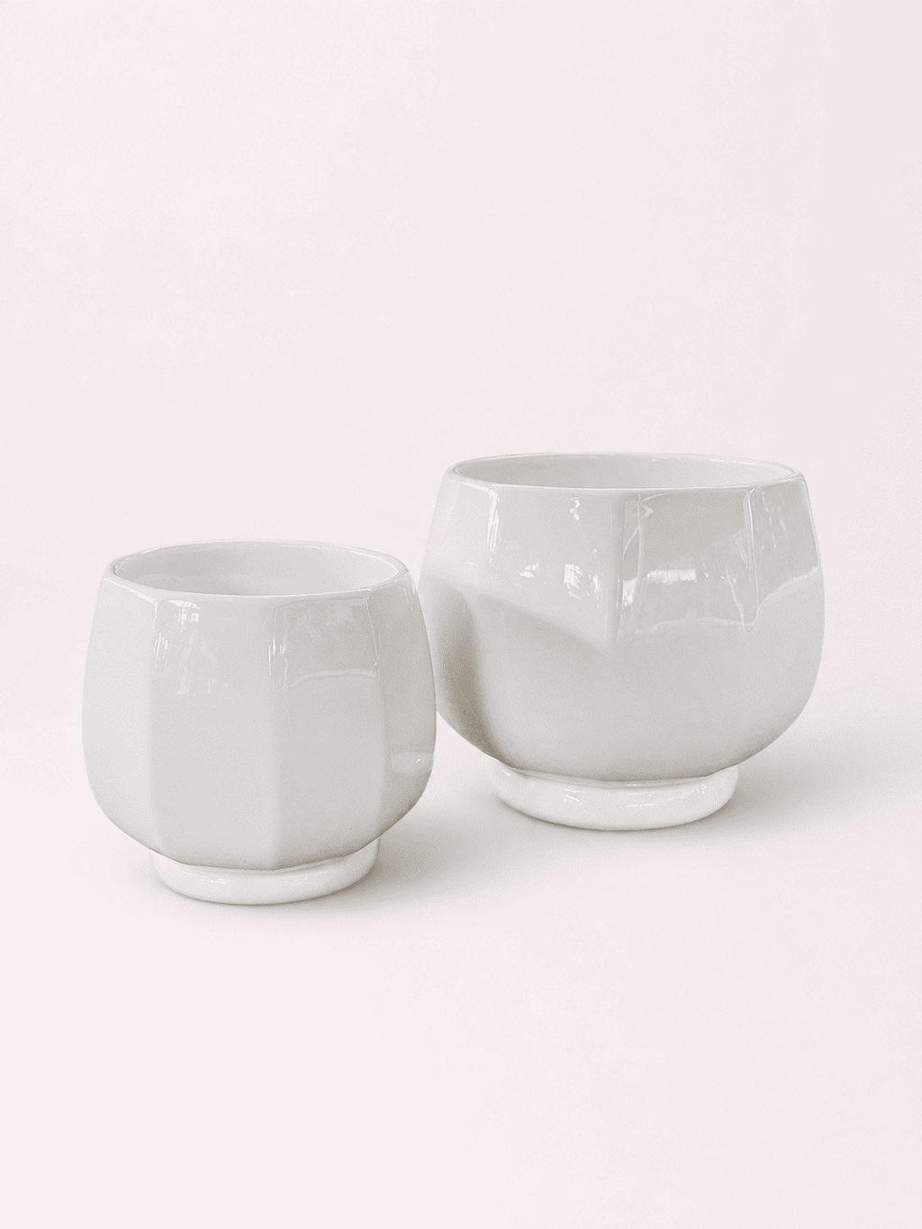 White ceramic low round planter pots, short wide cups with smooth glossy finish.