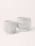 White ceramic low round planter pots, short wide cups with smooth glossy finish.