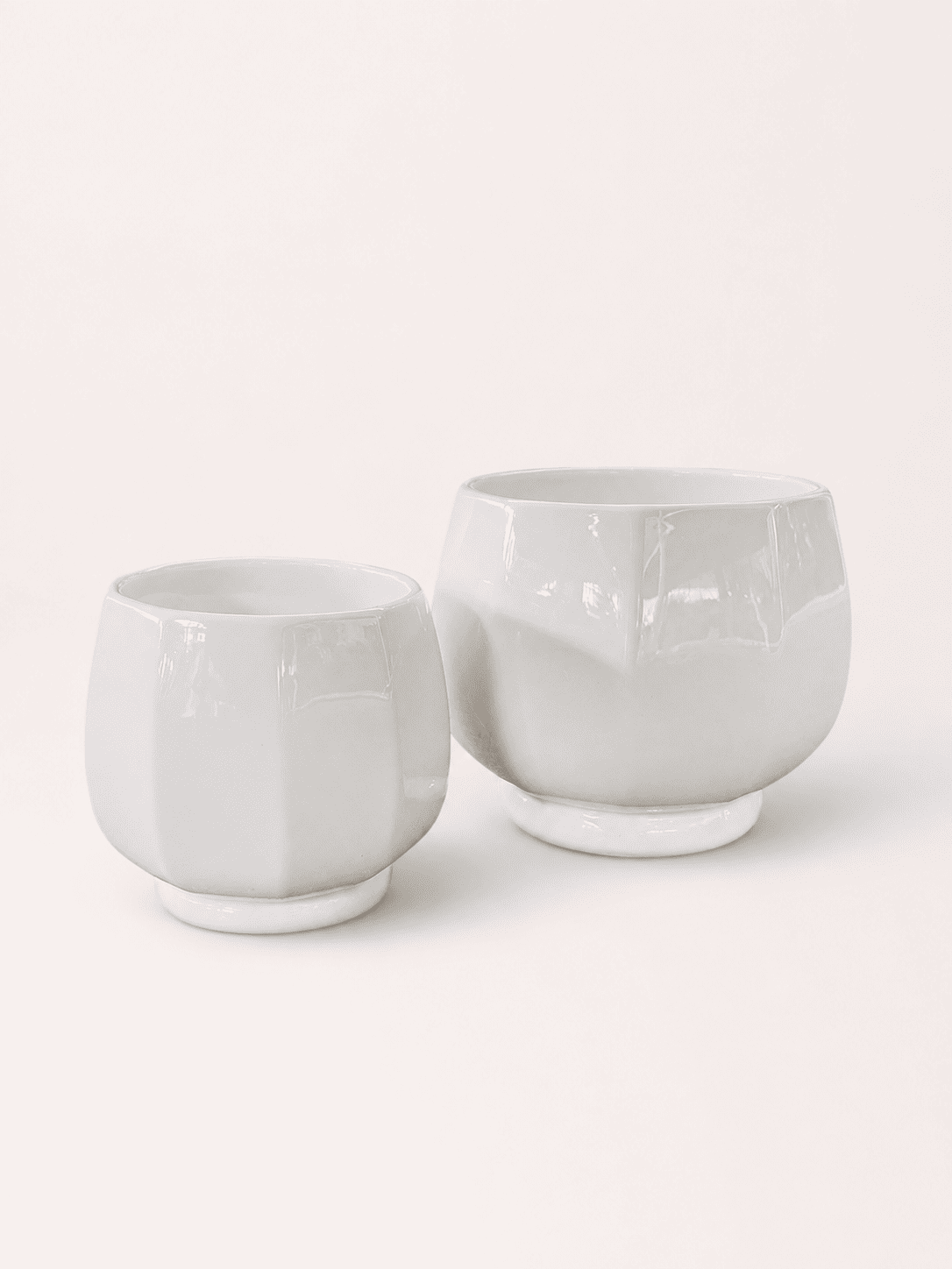 White ceramic low round planter pots, short wide cups with smooth glossy finish.