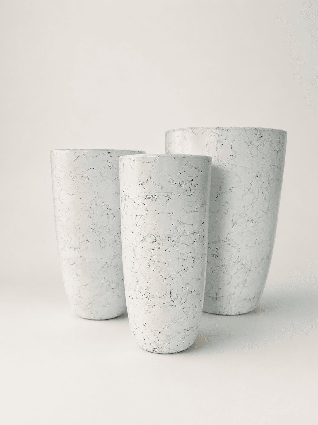 Set of three tall ceramic pots with white and gray marble pattern, round tapered shape