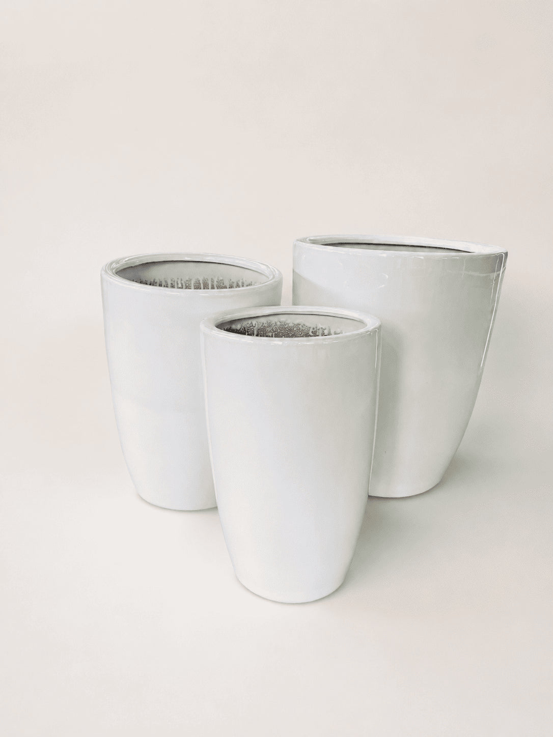 Set of three white ceramic tall planters with open tops