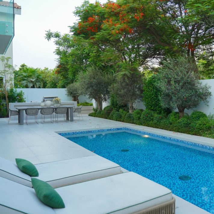 Outdoor setting with a pool, lounge chairs, and dining area.